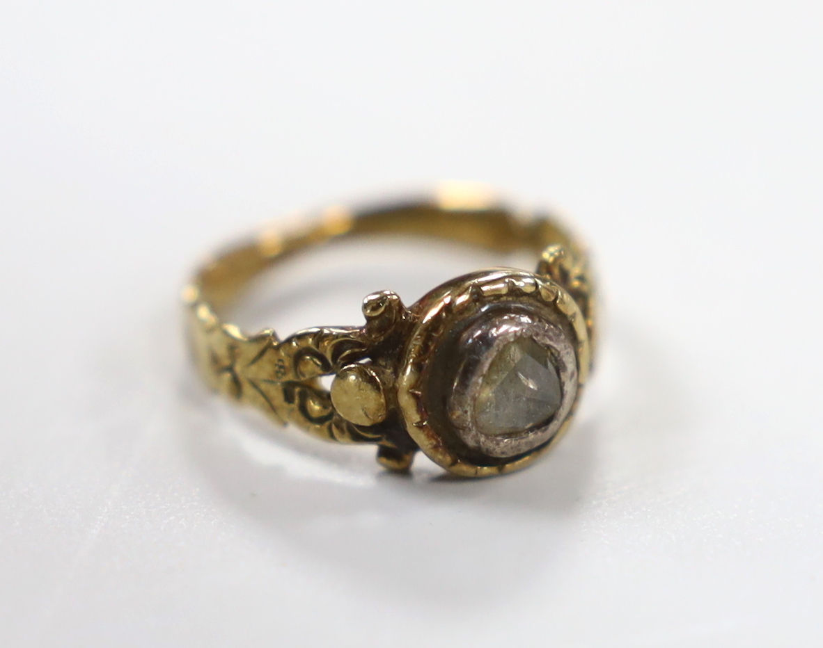 An early 19th century yellow metal and collet set rose cut diamond ring, with carved shoulders, size F, gross weight 2.4 grams.